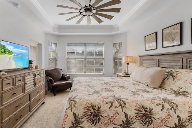 carpeted bedroom featuring crown molding, ceiling fan, and a tray ceiling