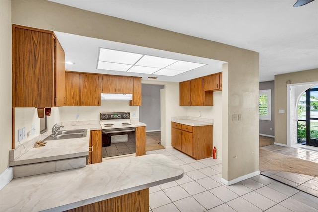 kitchen with white electric stove, light tile patterned flooring, and sink