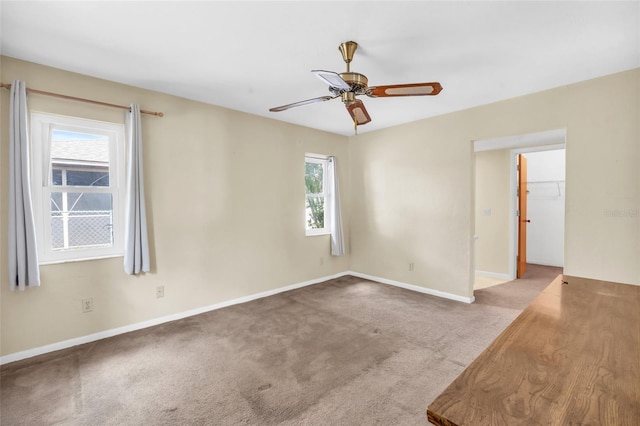 spare room with ceiling fan, light colored carpet, and a wealth of natural light