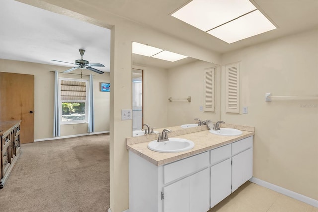 bathroom with vanity, ceiling fan, and a skylight