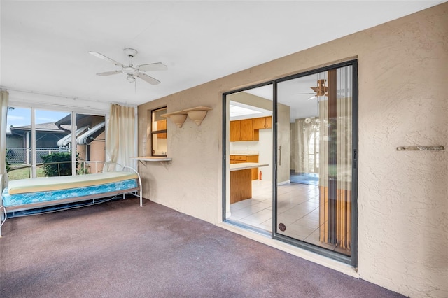 unfurnished sunroom featuring ceiling fan