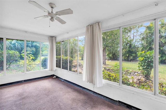 unfurnished sunroom featuring ceiling fan