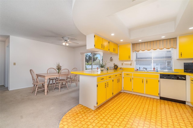 kitchen featuring kitchen peninsula, light colored carpet, sink, stainless steel dishwasher, and ceiling fan