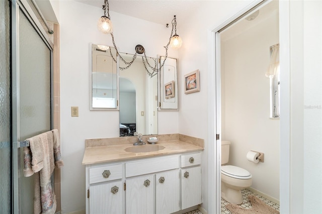 bathroom featuring toilet, vanity, and a shower with door