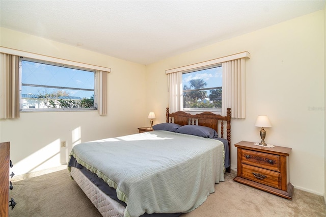 bedroom with a textured ceiling and light carpet