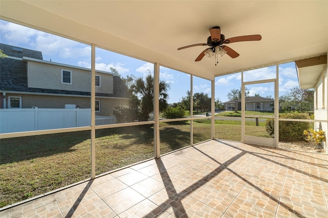 unfurnished sunroom with ceiling fan