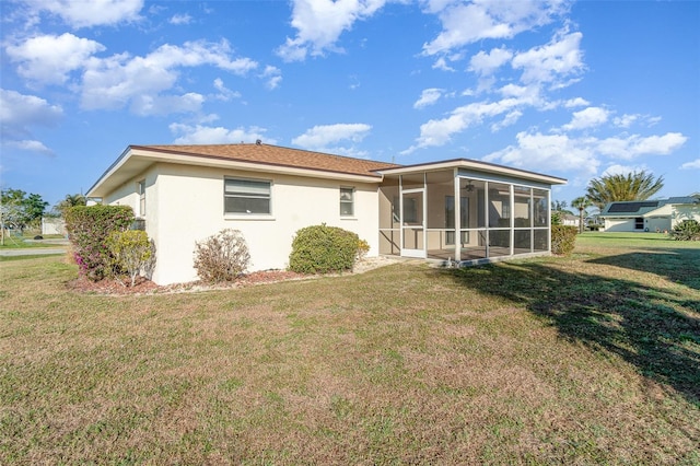 rear view of house featuring a yard and a sunroom