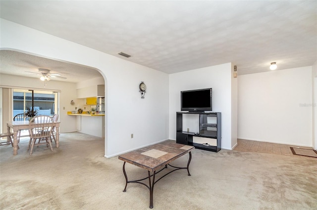 carpeted living room with ceiling fan