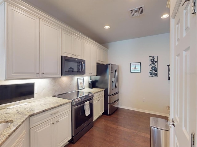 kitchen with stainless steel appliances, white cabinetry, and light stone countertops