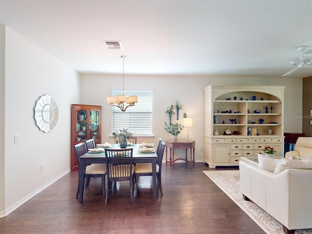 dining room featuring dark hardwood / wood-style flooring and ceiling fan with notable chandelier