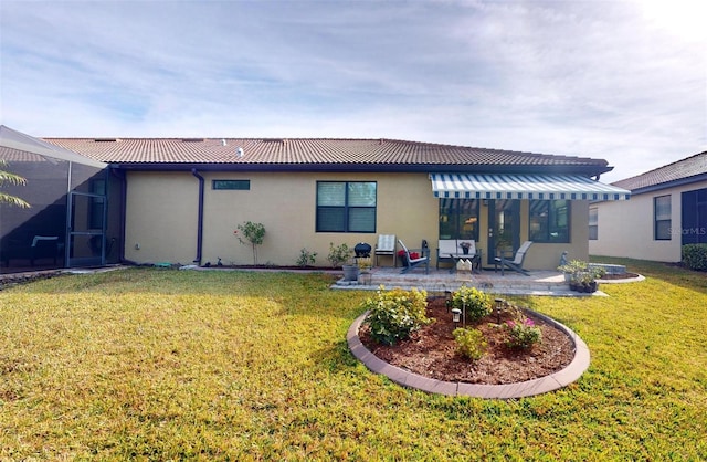 rear view of house with a lanai, a lawn, and a patio area