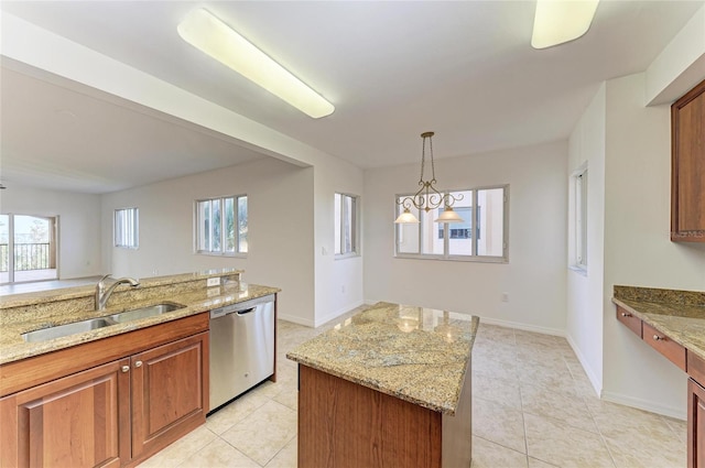 kitchen featuring light stone countertops, dishwasher, a center island, and sink