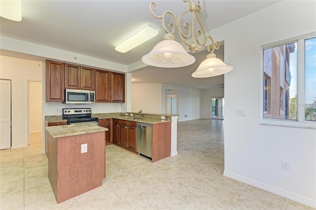 kitchen featuring sink, decorative light fixtures, appliances with stainless steel finishes, kitchen peninsula, and a wealth of natural light