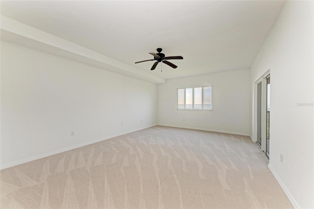 spare room featuring light colored carpet and ceiling fan