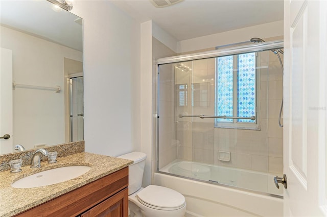 full bathroom with vanity, toilet, and combined bath / shower with glass door