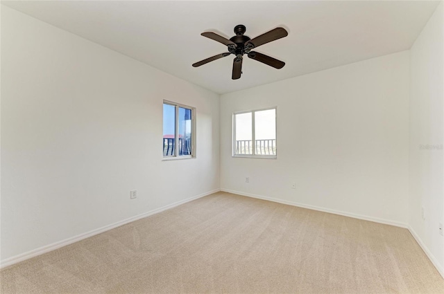 carpeted spare room with ceiling fan