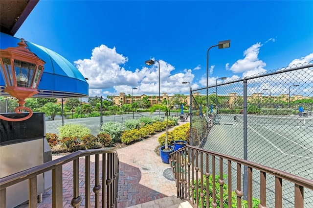 view of home's community featuring tennis court