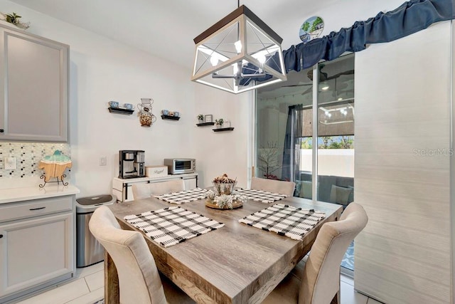 tiled dining room with an inviting chandelier