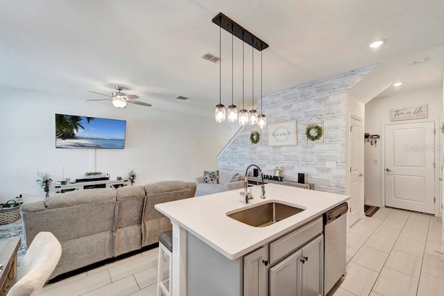 kitchen featuring pendant lighting, sink, ceiling fan, dishwasher, and a center island with sink