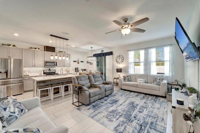 tiled living room featuring sink and ceiling fan