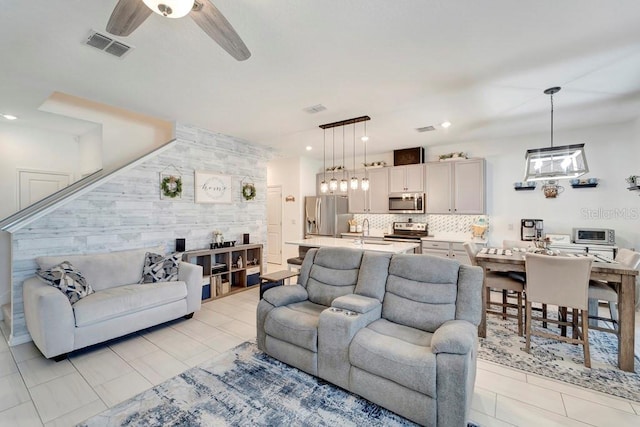 living room featuring ceiling fan and sink