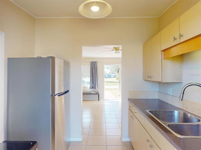 21456 Holdern Ave, Port Charlotte, FL 33952 - kitchen with cream cabinets, stainless steel refrigerator, sink, ceiling fan, and light tile patterned floors