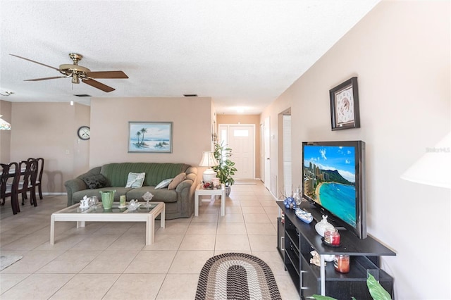 living room featuring ceiling fan, a textured ceiling, and light tile patterned flooring