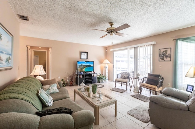 living room featuring ceiling fan, a textured ceiling, and light tile patterned floors