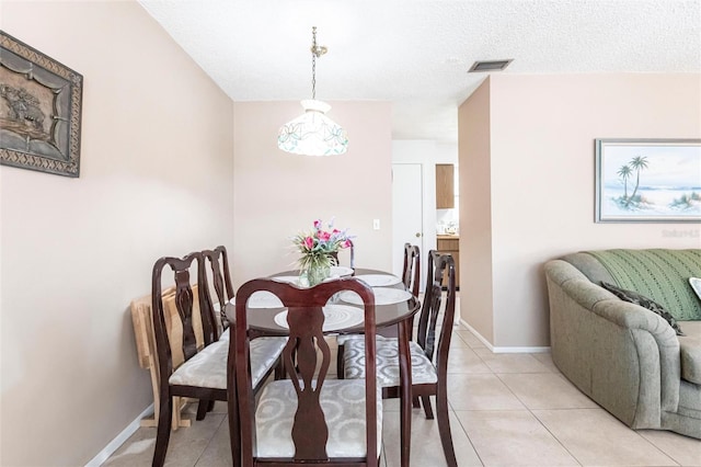 tiled dining room with a textured ceiling