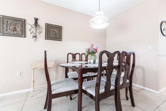 tiled dining room featuring a textured ceiling