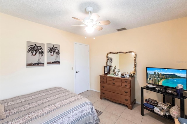 tiled bedroom featuring ceiling fan and a textured ceiling