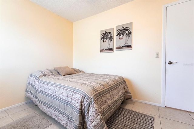 bedroom featuring a textured ceiling and light tile patterned floors