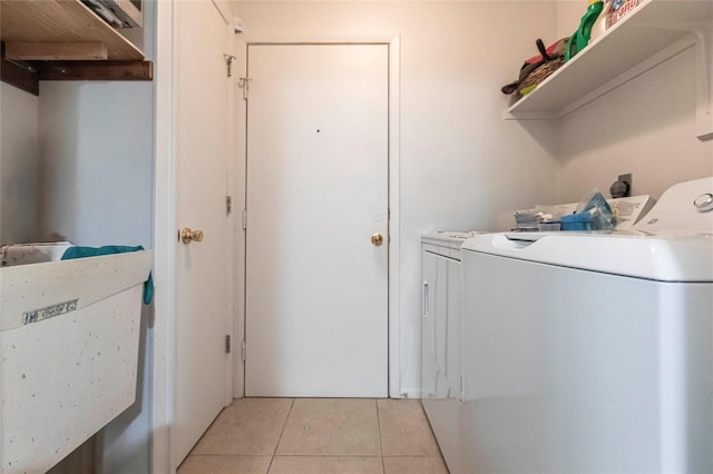 clothes washing area with light tile patterned flooring and washer and dryer