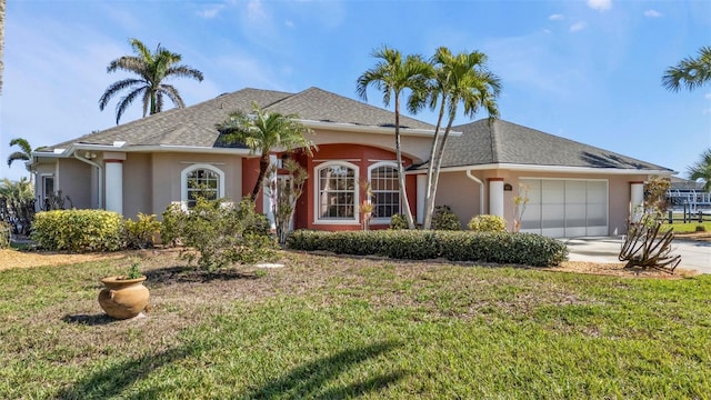 view of front of home with a shingled roof, concrete driveway, an attached garage, a front lawn, and stucco siding