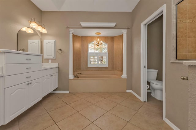 full bath with toilet, tile patterned floors, a garden tub, vanity, and a notable chandelier