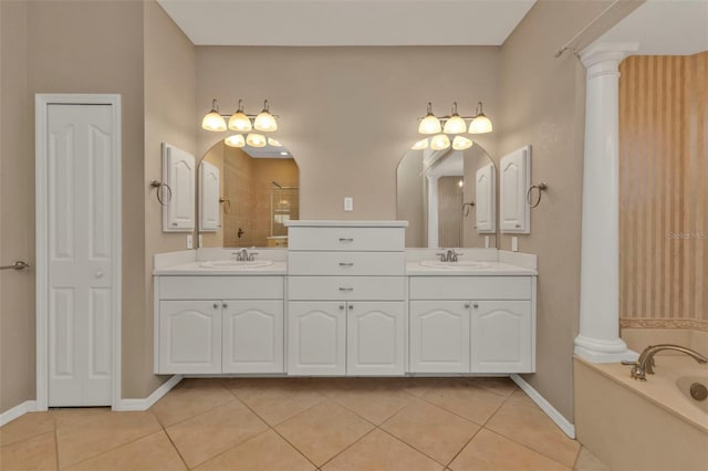 full bath featuring decorative columns, a sink, and tile patterned floors