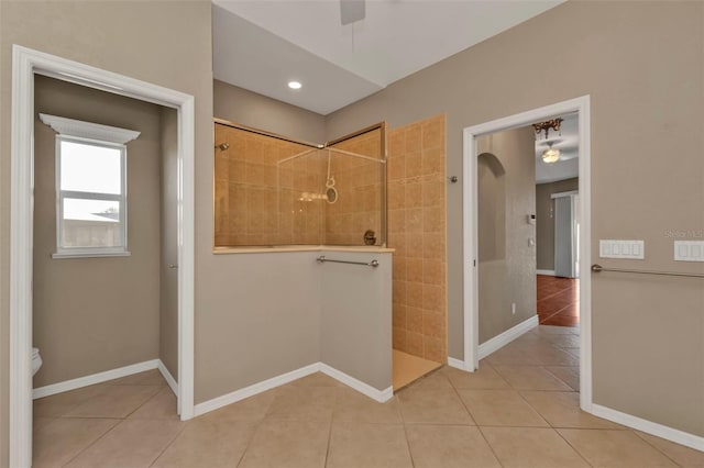 full bath with a walk in shower, ceiling fan, tile patterned flooring, and baseboards