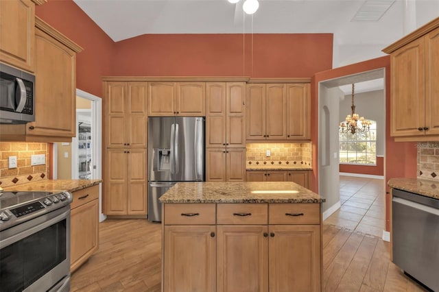 kitchen with light stone counters, a chandelier, decorative backsplash, stainless steel appliances, and light wood-type flooring