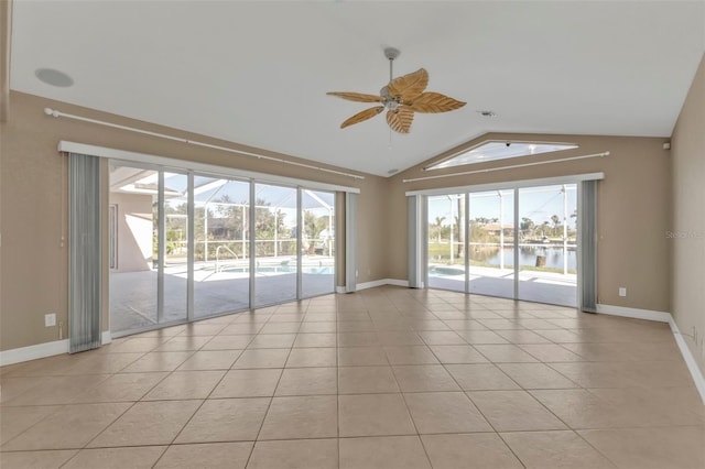 unfurnished room featuring a water view, baseboards, light tile patterned flooring, vaulted ceiling, and a ceiling fan