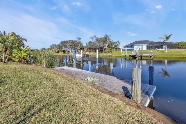 dock area featuring a water view and a lawn