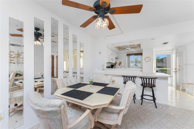 dining area featuring ceiling fan and light carpet