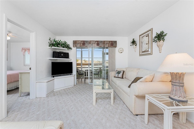 carpeted living room with ceiling fan