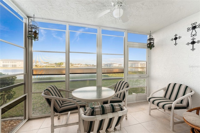 sunroom featuring a water view and ceiling fan