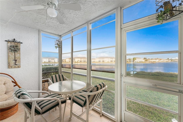 sunroom featuring a water view and ceiling fan