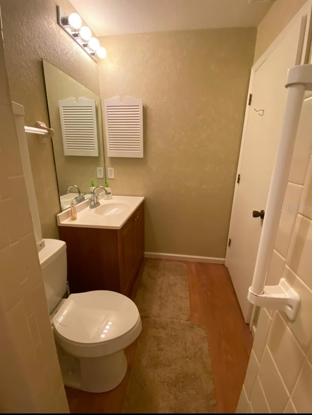 bathroom with vanity, hardwood / wood-style floors, and toilet