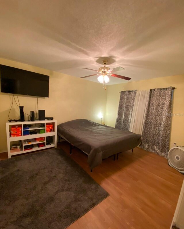 bedroom with ceiling fan and wood finished floors