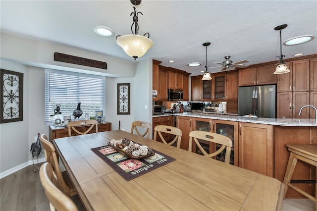 dining space featuring sink, ceiling fan, and light hardwood / wood-style flooring