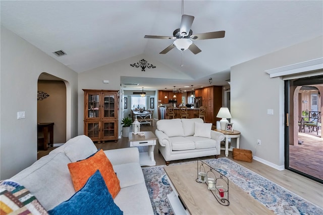 living room featuring ceiling fan, lofted ceiling, and light hardwood / wood-style flooring