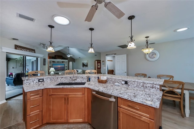 kitchen with pendant lighting, sink, dishwasher, light hardwood / wood-style floors, and an island with sink