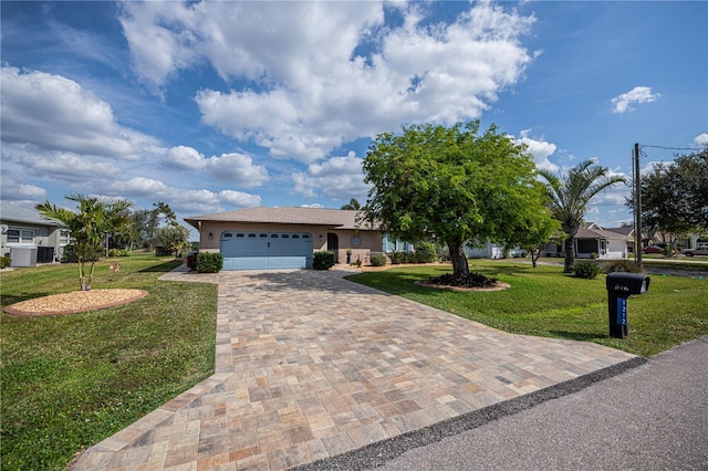 single story home with a garage, a front yard, and cooling unit